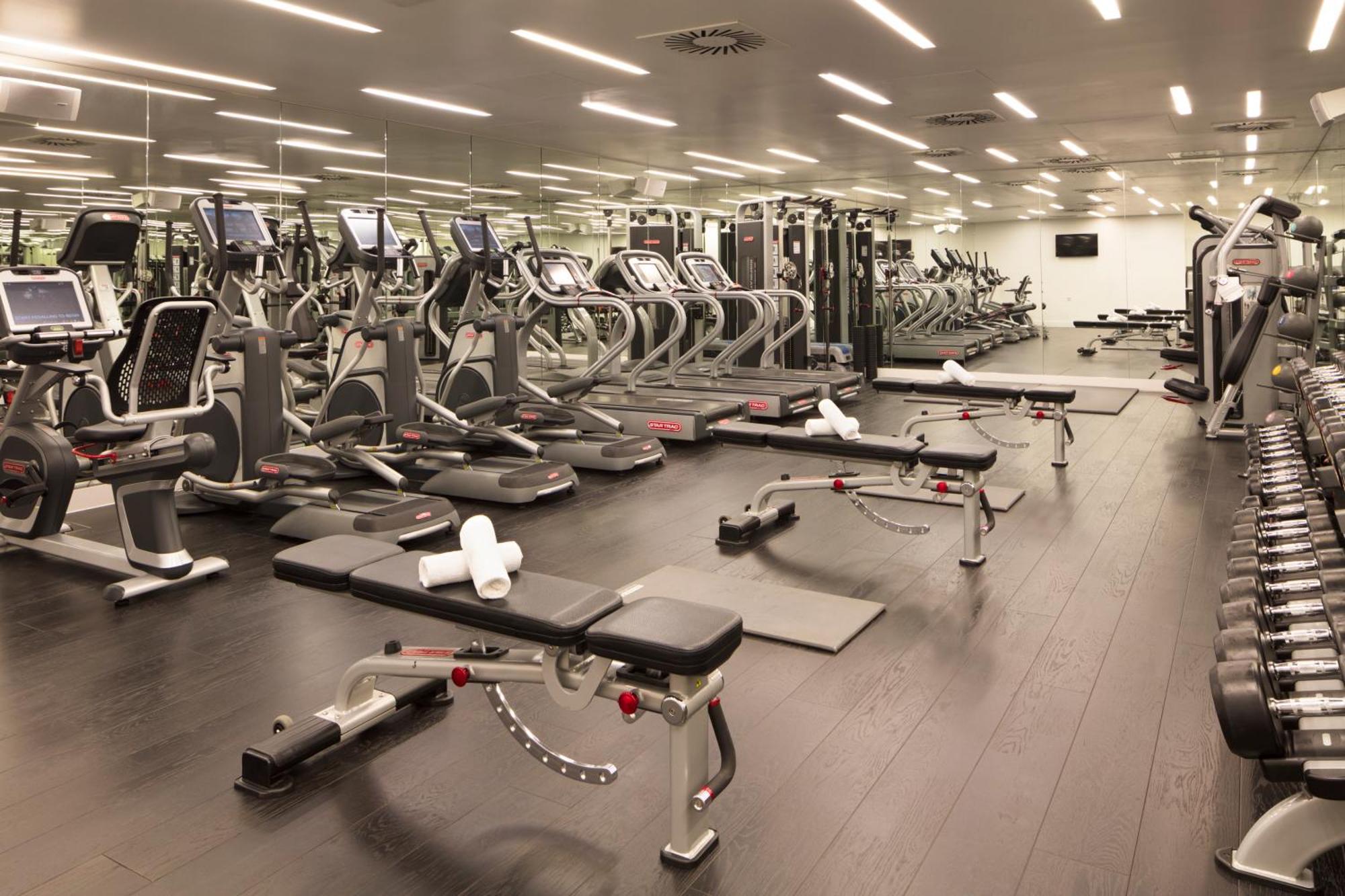 Sea Containers London Hotell Eksteriør bilde The photo shows a modern gym interior. There are several exercise machines arranged neatly, including treadmills and weight training machines. The floor is dark, and the gym is well-lit with overhead lighting. In the foreground, there are benches for